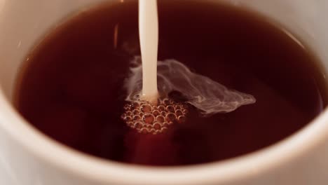 Macro-shot-captures-milk-pouring-into-a-coffee-cup,-revealing-intricate-details