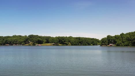 Revelar-Detrás-De-Las-Ramas-De-Un-Hermoso-Lago-Escénico-Con-árboles-Que-Rodean-La-Costa