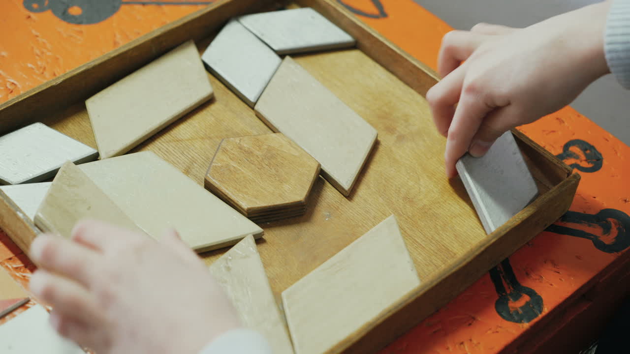 Close-up, hands of a child playing with a wooden puzzle. Concept of education.