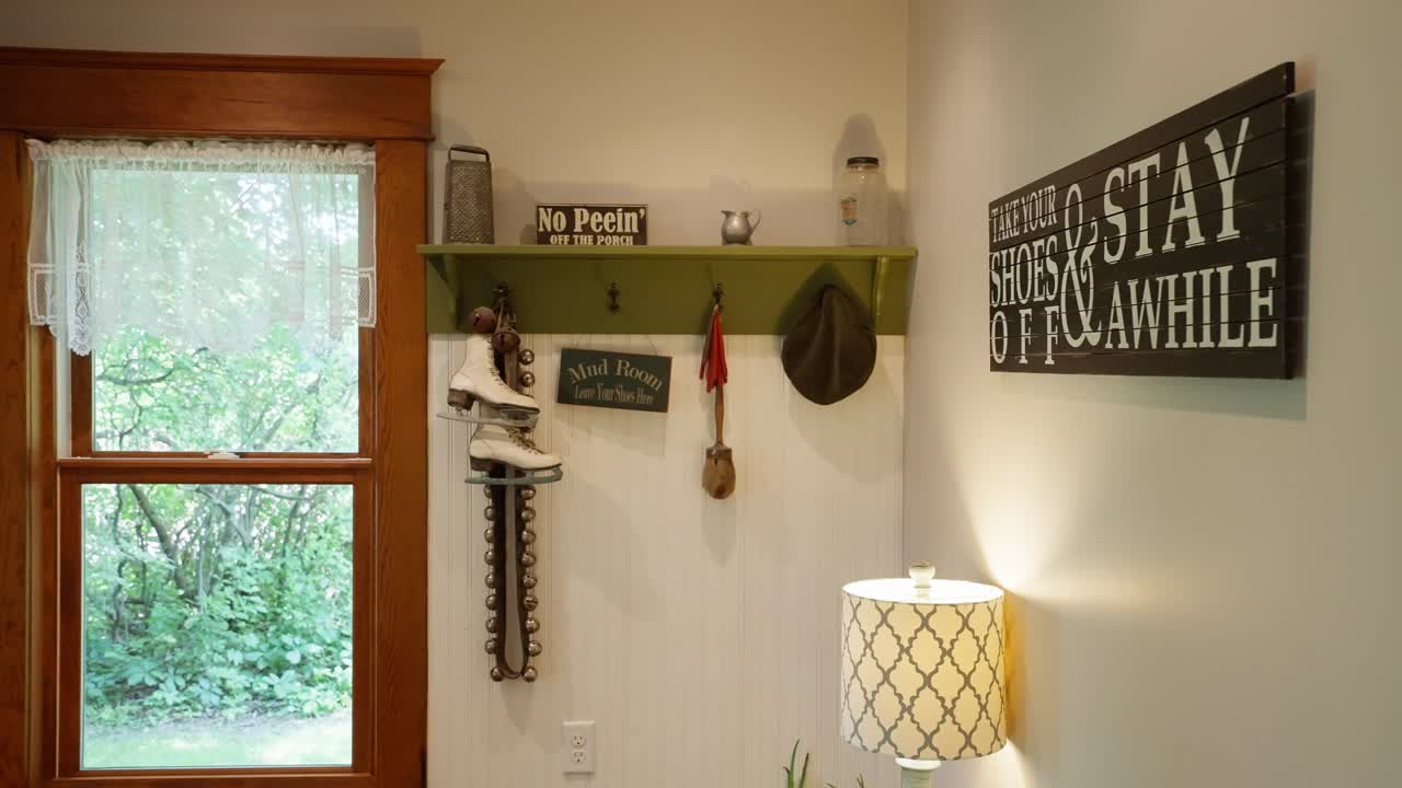 disparo panorámico de una habitación de barro con perchas de abrigo y decoraciones inteligentes en la pared