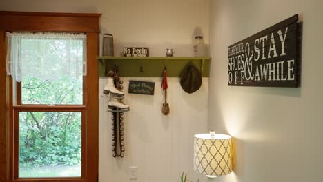 panning shot of a mud room with coat hanger and clever decorations on the wall