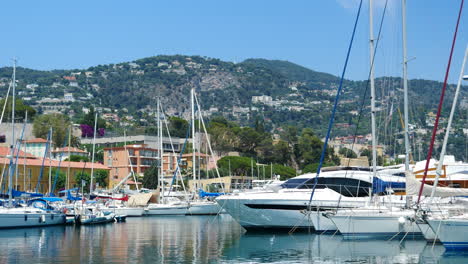 Luxury-yachts-and-boats-moored-in-Villefranche-sur-Mer-harbour,-pan-shot