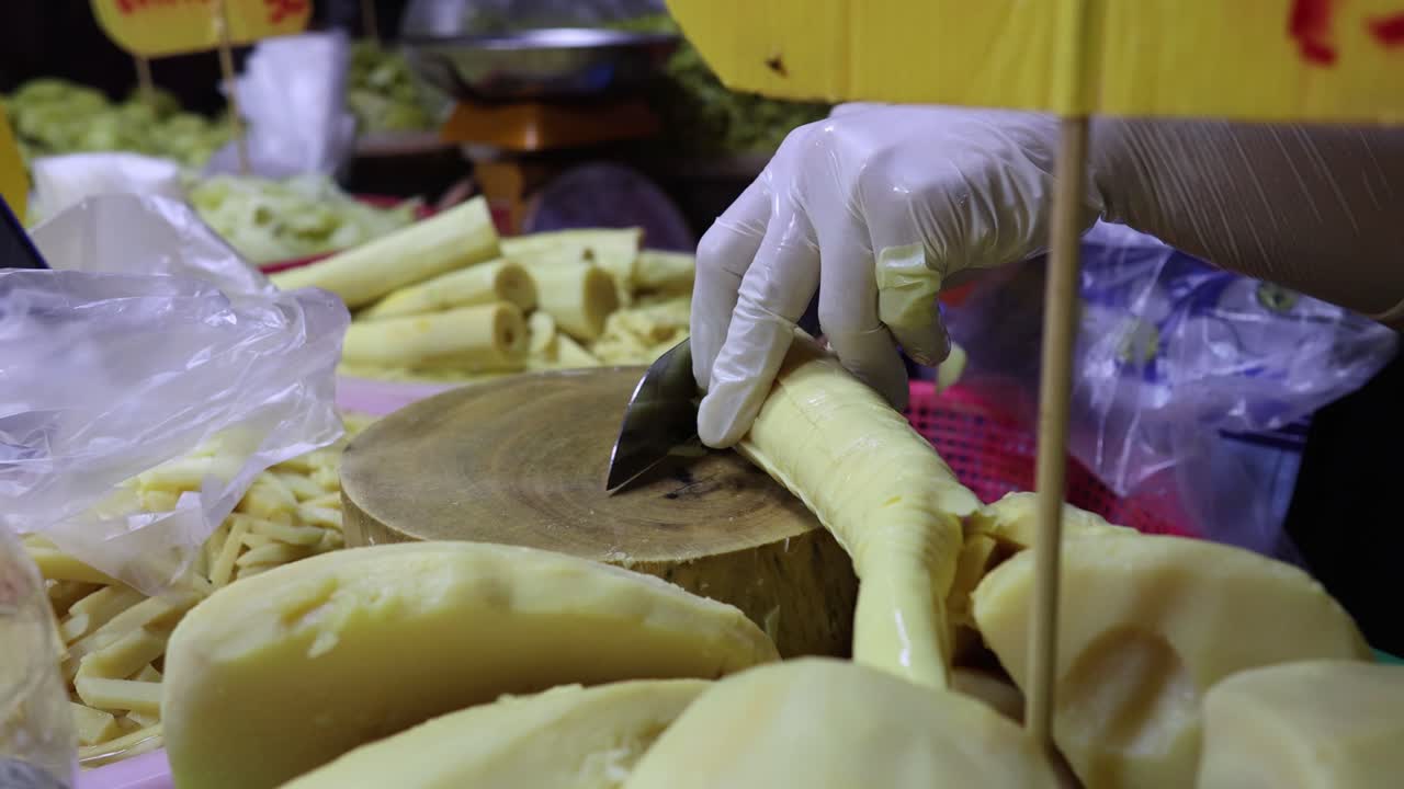 persona cortando hábilmente los brotes de bambú en pedazos