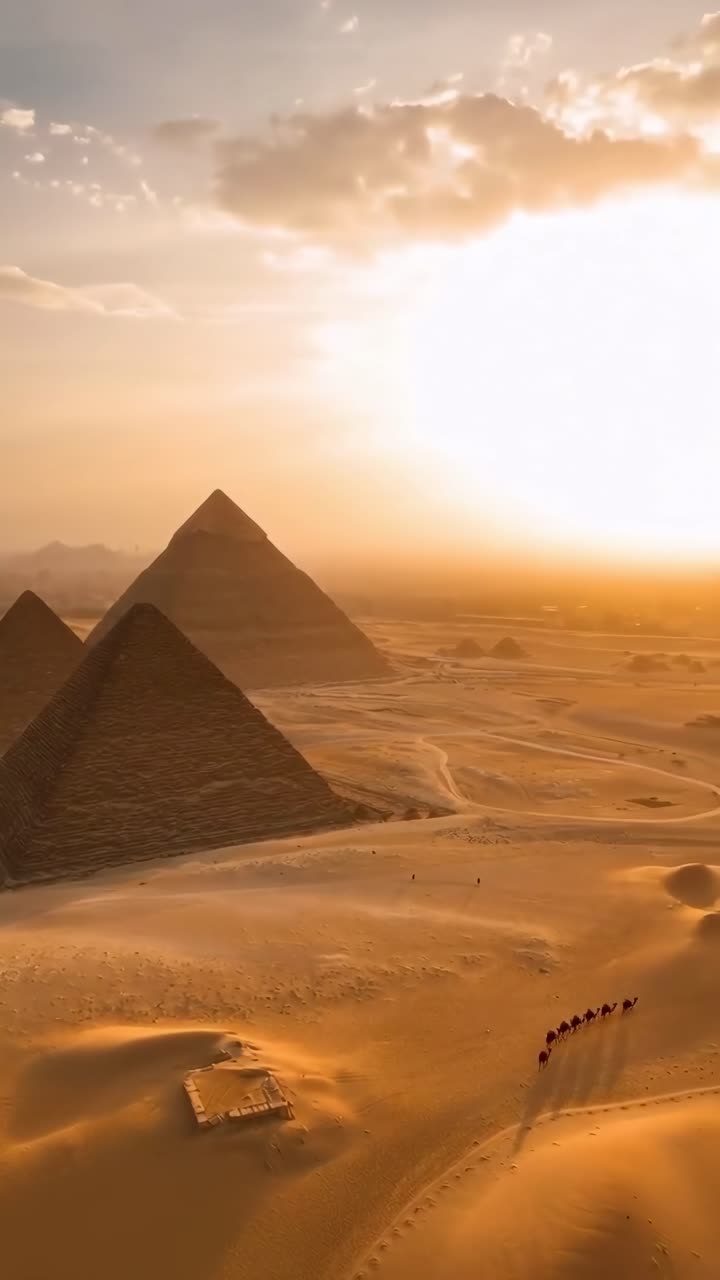 Ripresa video aerea di piramidi al tramonto, che cattura un vasto paesaggio desertico e tonalità calde.