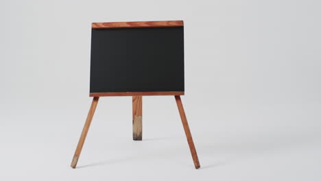 video de un letrero de pizarra en un soporte de madera con espacio de copia en un fondo blanco