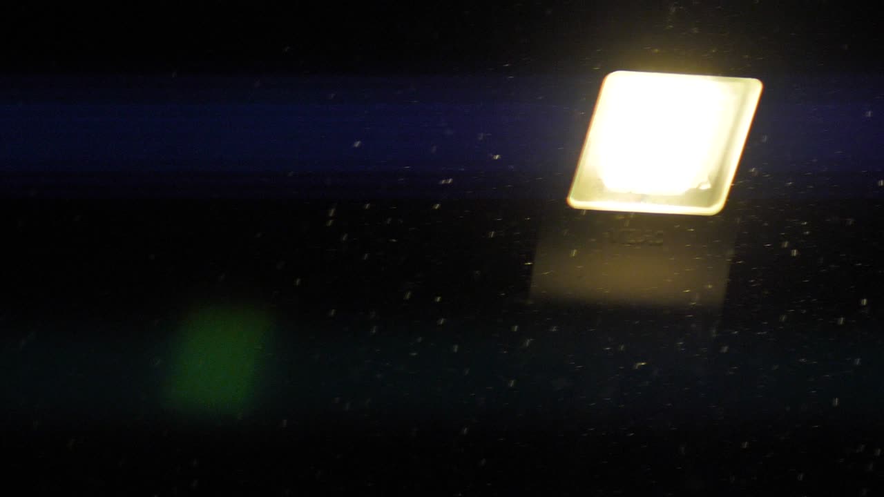 las linternas brillan por la noche con pequeños copos de nieve