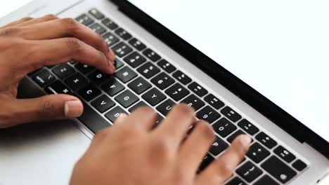 Close-up-view-of-a-young-businessman's-busy-hands-working-on-a-laptop-or-computer-keyboard,-sending-emails,-and-surfing-on-a-web-browser