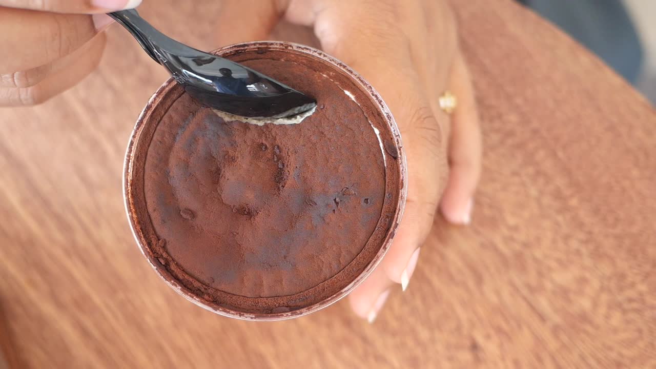 una mujer comiendo tiramisu.