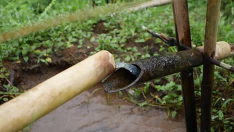 a clever device built from bamboo that tips over when the water gets full in the pipe and drops it into the pond beneath