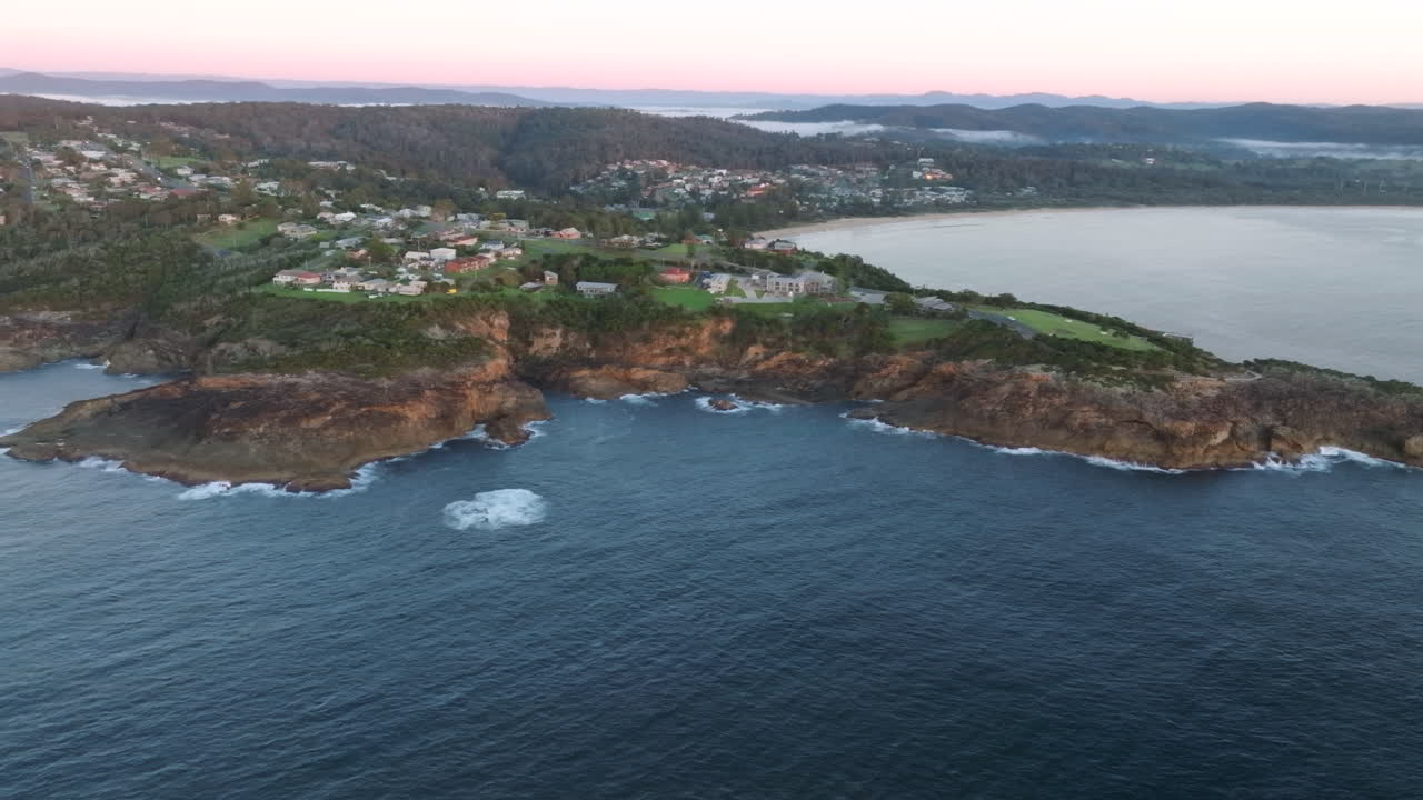 Aerial: High up drone shot of Tathra and the surrounding landscape on South Coast NSW, Australia