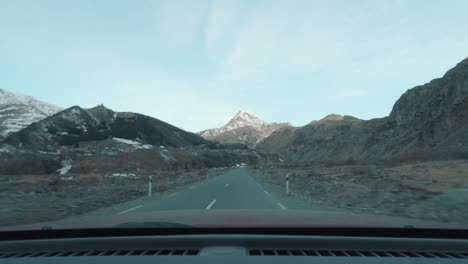 En-El-Camino-A-Las-Montañas-Cubiertas-De-Nieve,-Se-Puede-Observar-La-Tierra-árida