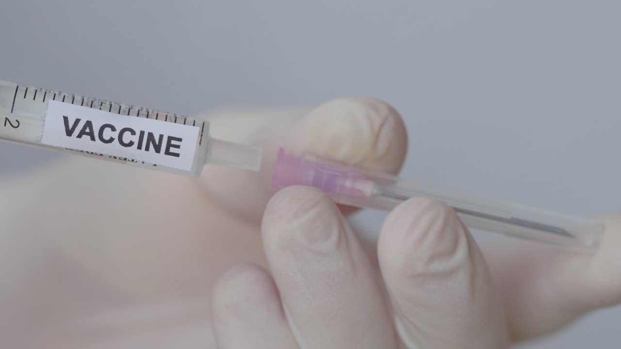 guante de mano que coloca la aguja en la inyección médica con vacuna, toma de primer plano