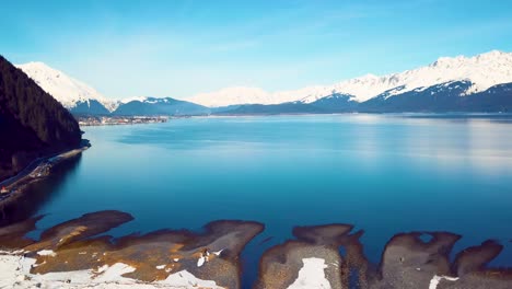 4k drone video of seward, alaska beach and surrounding snow covered mountains on snowy winter day