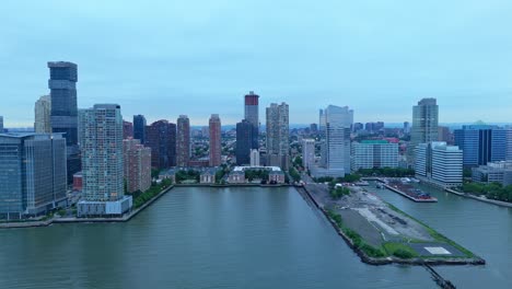 jersey city skyline along hudson river, modern high-rise buildings and waterfront on cloudy, overcast day, new jersey, usa