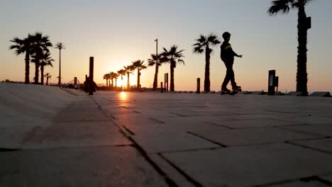 un niño jugando a los rodillos en una hermosa puesta de sol