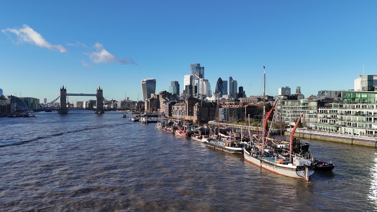 Old sailing barges moored on river Thames Tower bridge London UK in background