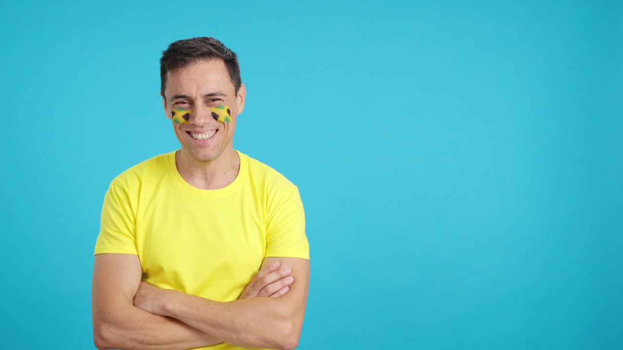 Man standing with jamaican flag painted on face smiling