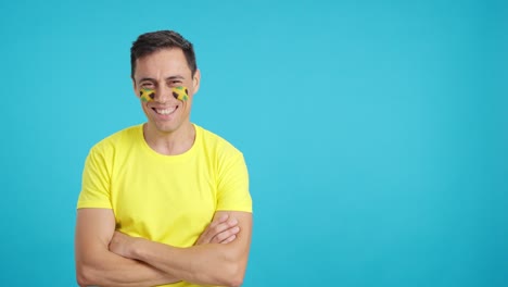 Man standing with jamaican flag painted on face smiling