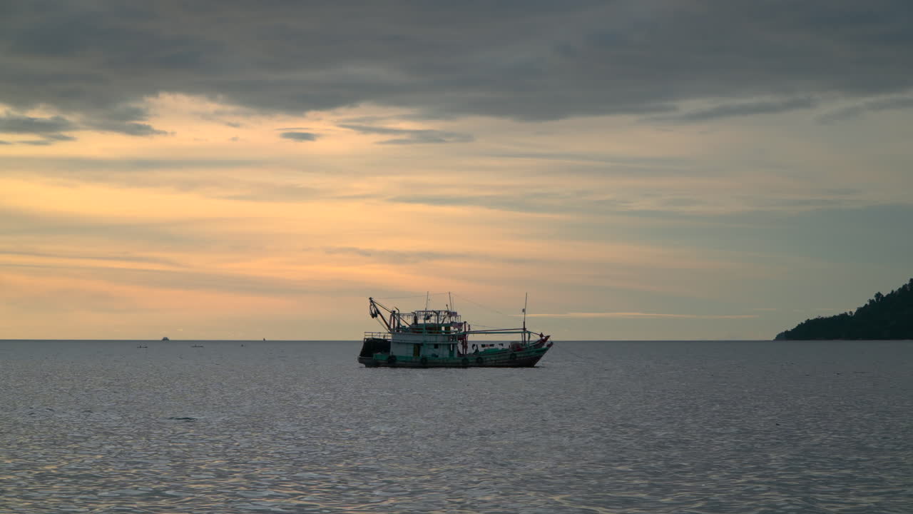 배경에 일몰과 함께 바다에 정박 한 어선 트롤 어선