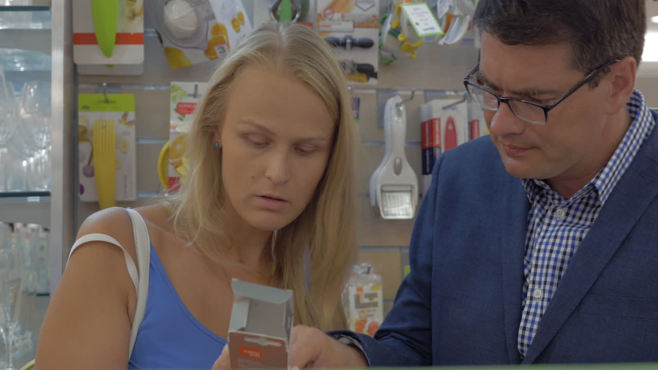 una pareja joven en la sección de utensilios de cocina.