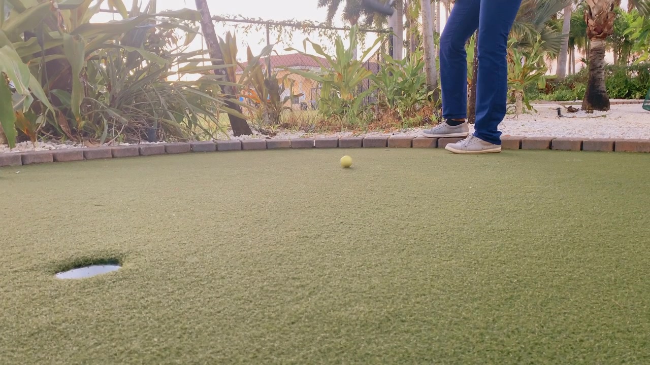 Persona che gioca a minigolf mancando la buca