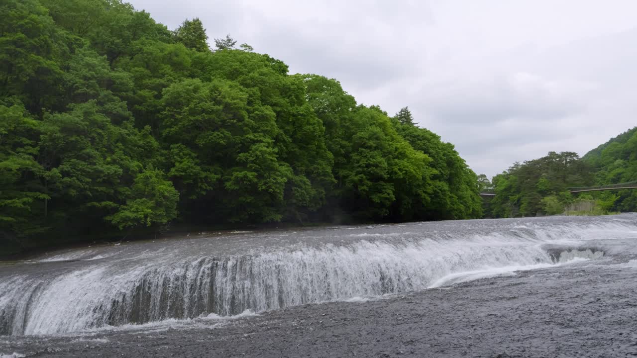 Slow motion panning shot over Fukiware waterfalls in Gunma on cloudy day
