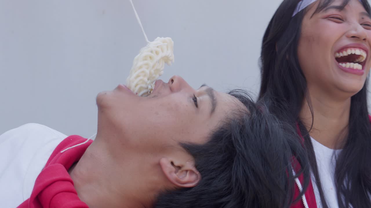 젊은 남녀가 인도네시아 독립기념일에 크래커를 먹는 대회에 참가하는 클로즈업