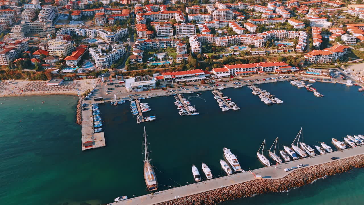 Coastal marina bustling with activity. A vibrant marina filled with boats and a picturesque coastal town in the background during the golden hour