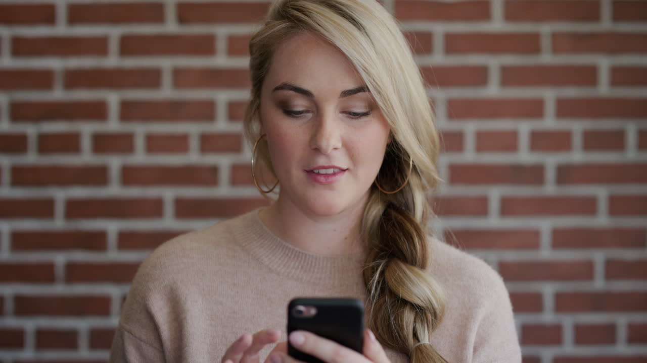 ritratto ravvicinato bella giovane donna bionda che usa lo smartphone navigando inviando messaggi di testo godendo della comunicazione mobile slow motion