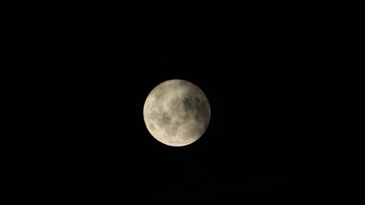 Nuvens se movendo em frente a uma lua cheia à noite, Maffra, Gippsland, Victoria, Austrália.