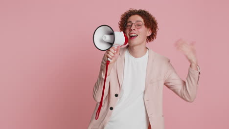 young man talking with megaphone, proclaiming news, loudly announcing advertisement discounts sale