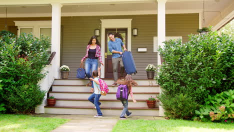 familia con equipaje saliendo de casa para ir de vacaciones