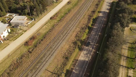 aerial track shot of car driving on rural road in suburb area of buenos aires during sunset,argentina