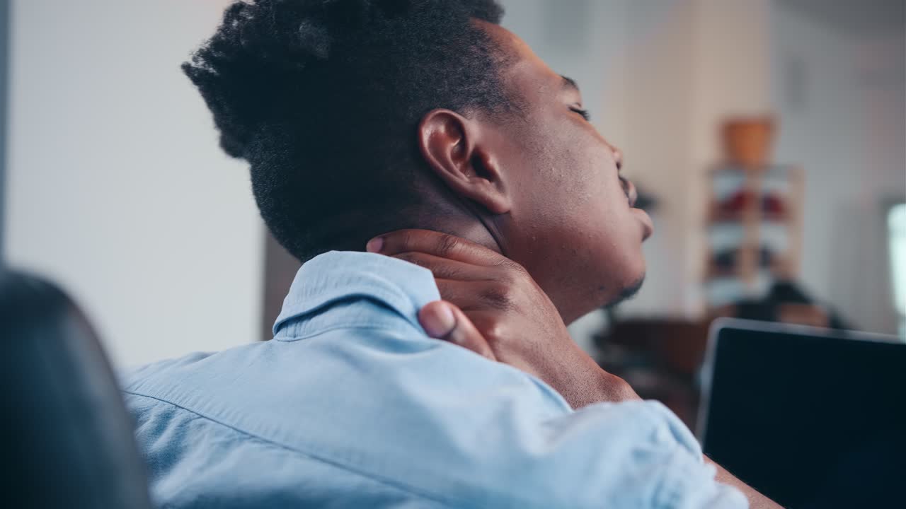 Man experiencing neck pain at his workplace
