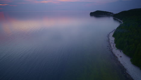 drone shot flying up the coast of lake michigan near fayette historic state park just after the sun had set