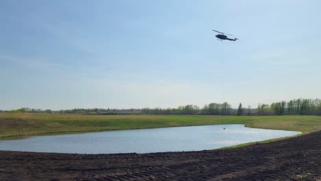 Helikopter-Eimer-Sammelt-Wasser-Aus-Dem-Nahegelegenen-See-Während-Waldbränden,-Alberta,-Kanada