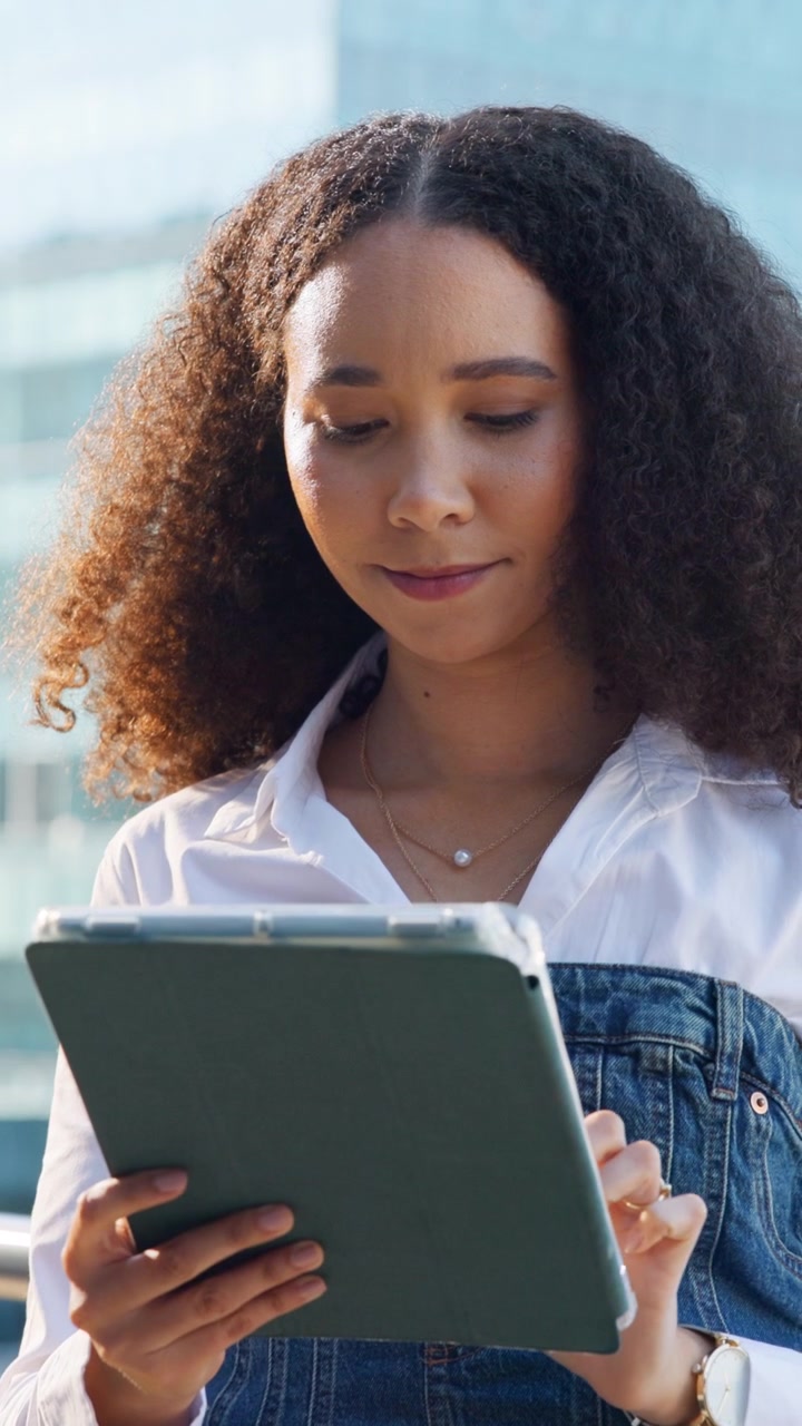 Young Woman Using a Tablet Outdoors in an Urban Setting