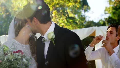 Bride-and-groom-kissing-while-guest-blowing-bubbles-4K-4k