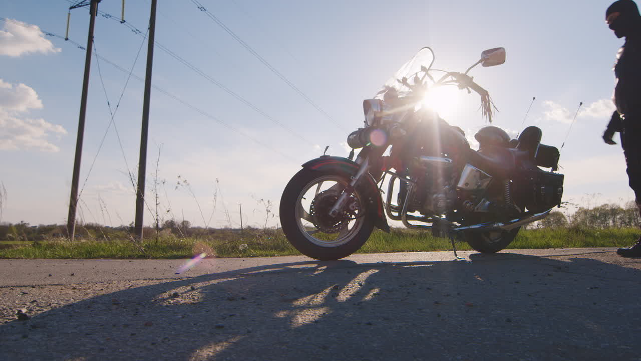 가죽 재킷을 입은 오토바이 운전자는 자전거에 앉아 윤곽 촬영을 벗어납니다.