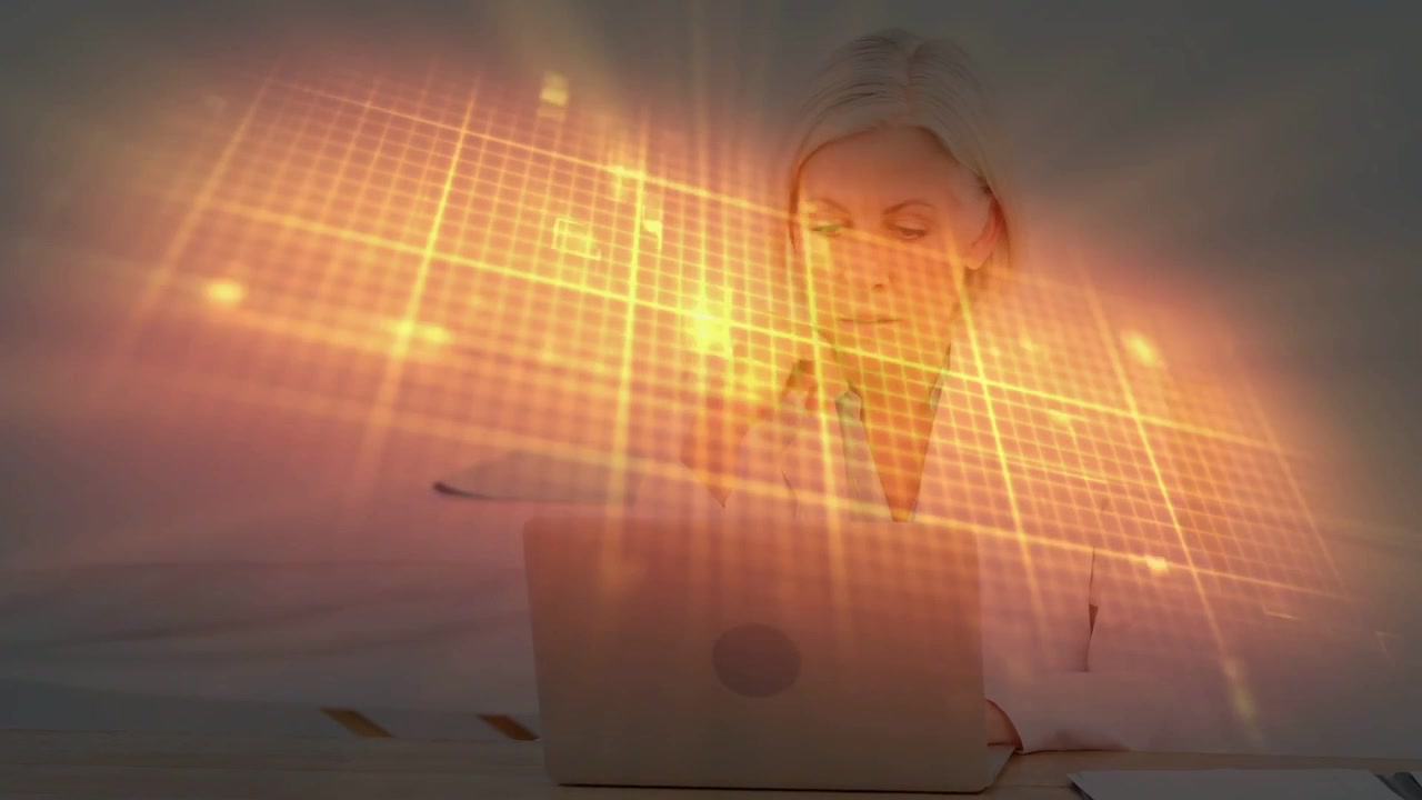 Donna matura che esamina il laptop per lavoro tecnologico mentre una griglia arancione appare e fluttua sopra il laptop.