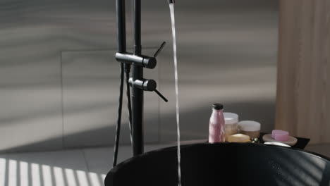 modern black bathtub filling with water