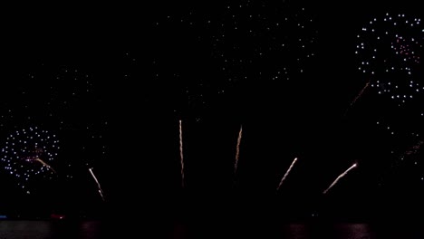increíble espectáculo de fuegos artificiales de colores sobre el mar en la noche de celebración