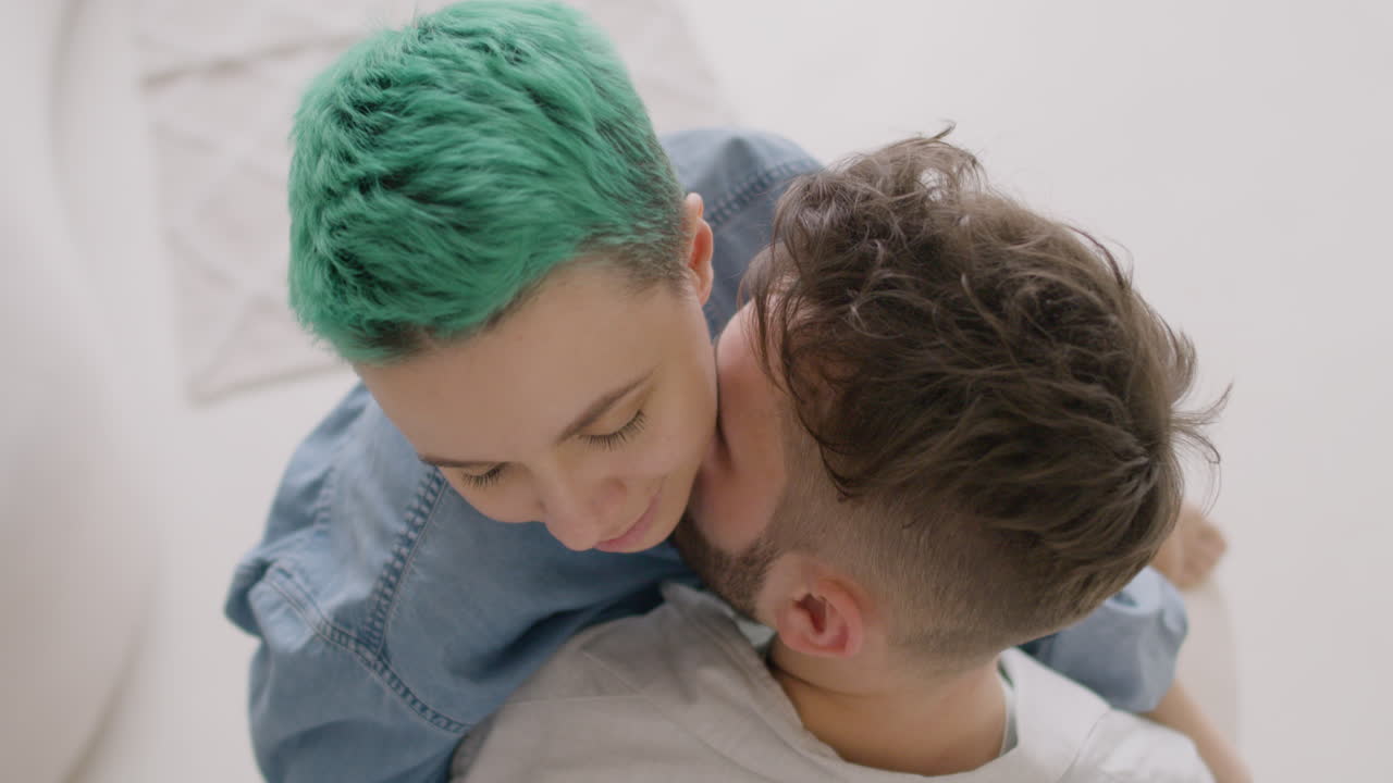 вид сверху на молодую пару, целующуюся и обнимающуюся, парень держит девушку, сидящую на стуле