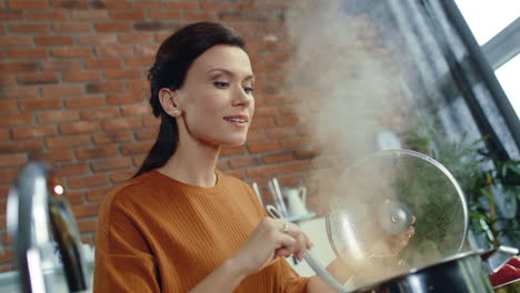 woman smelling hot soup in kitchen. housewife cooking meal at home kitchen.