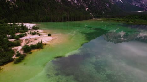 calm waters of braies lake in prags dolomites, south tyrol, italy - drone shot