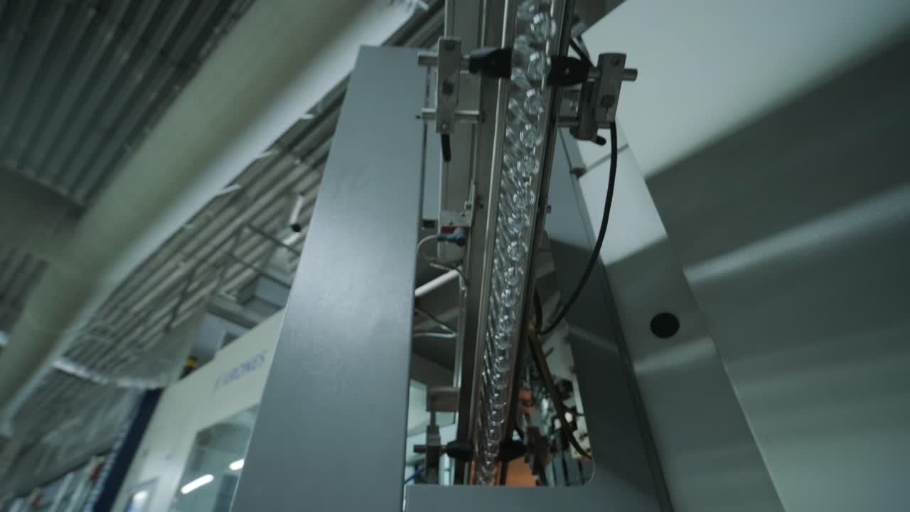 la máquina de llenado automático vierte agua en botellas de plástico para mascotas en una moderna planta de bebidas