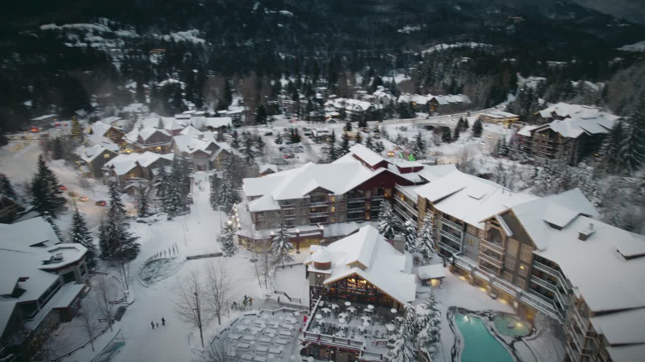 A massive, stunning hotel covered in snow located in the mountains of British Columbia, Canada.