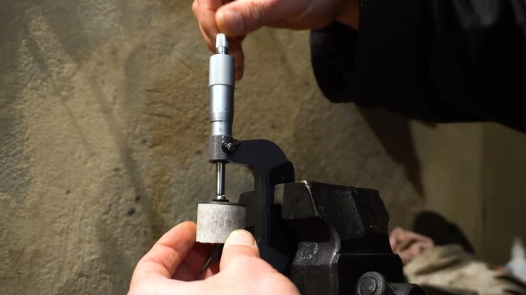 The man measures the motor part