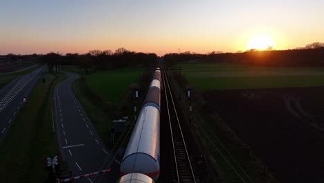 aerial view: train on tracks during golden hour sunset