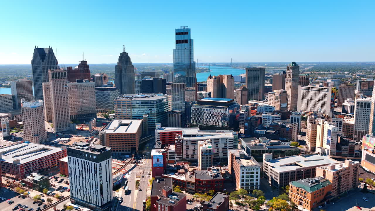 Multiple cars are parked in the downtown of modern Detroit, Michigan, USA. Beautiful blue waterscape of the Detroit River at backdrop. Detroit, USA, 28 July 2025: